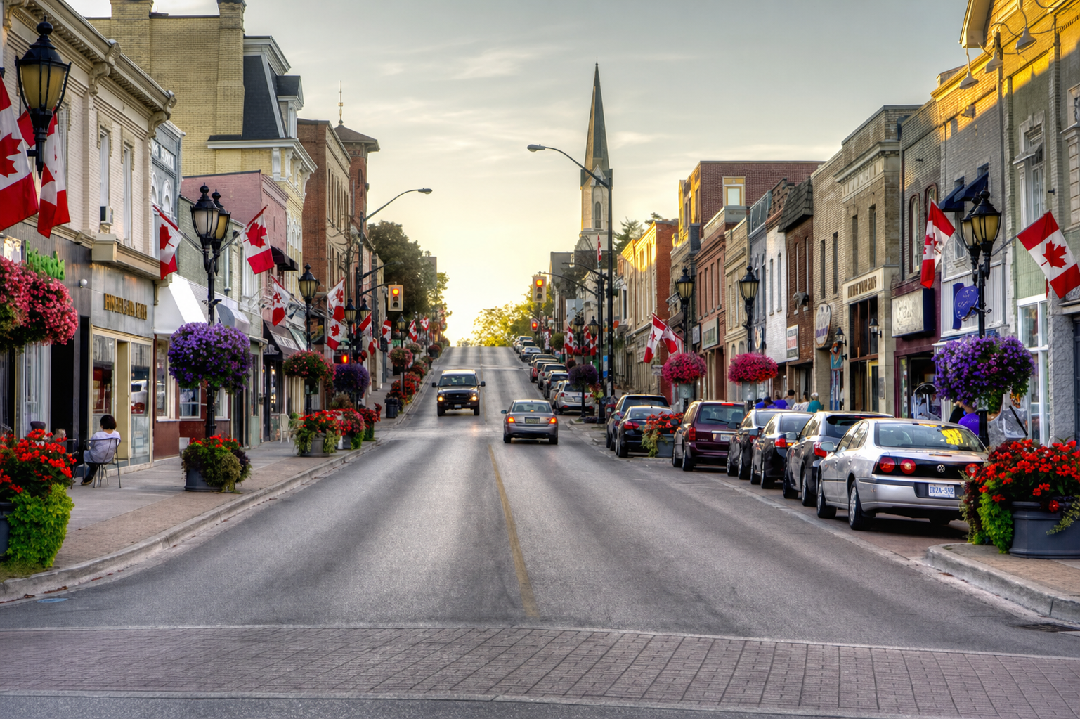 Historic Main Street in Newmarket, Ontario, lined with Canadian flags and flower baskets